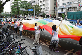 people holding up a large waving rainbow banner at the 2011 Taiwan LGBT Pride Parade