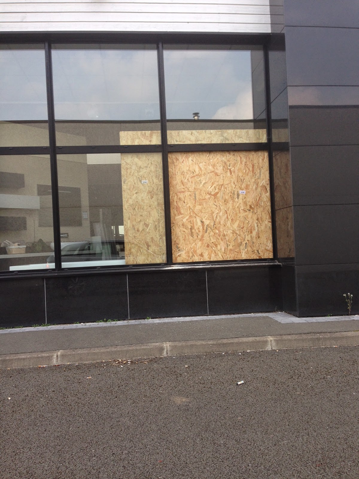 Fermeture provisoire d'une baie vitrée vandalisée sur Lille avant son remplacement.