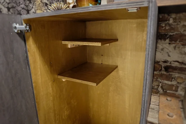 gold paint inside cabinet with two storage shelves