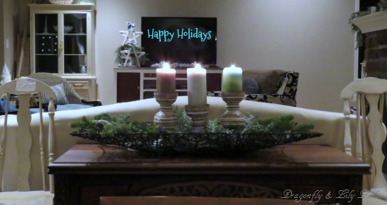 Happy Holiday written across the  television, candles, wooden stars  washed in white with plaid  turquoise.