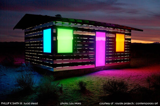 Cabaña transparente de madera y espejos en un paisaje desértico