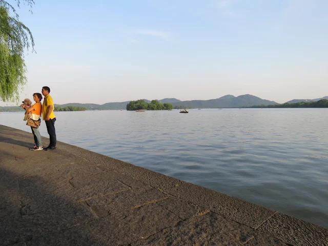 Posing for a photo with a dog on Hangzhou's West Lake