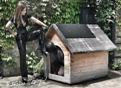 mistress with slave in rubber in a dog house