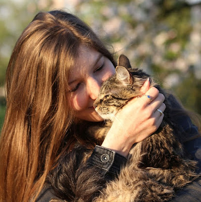 alt="chica feliz abrazando a su gato"
