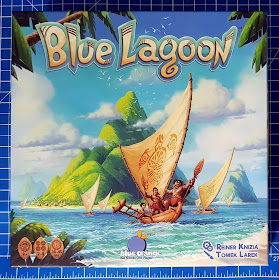 Blue Lagoon Family Game Review box front with pacific style drawing and wooden longboat with native people smiling
