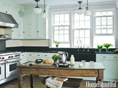 这个农舍厨房有华丽的绿松石橱柜和黑色台面，有一种复古的感觉