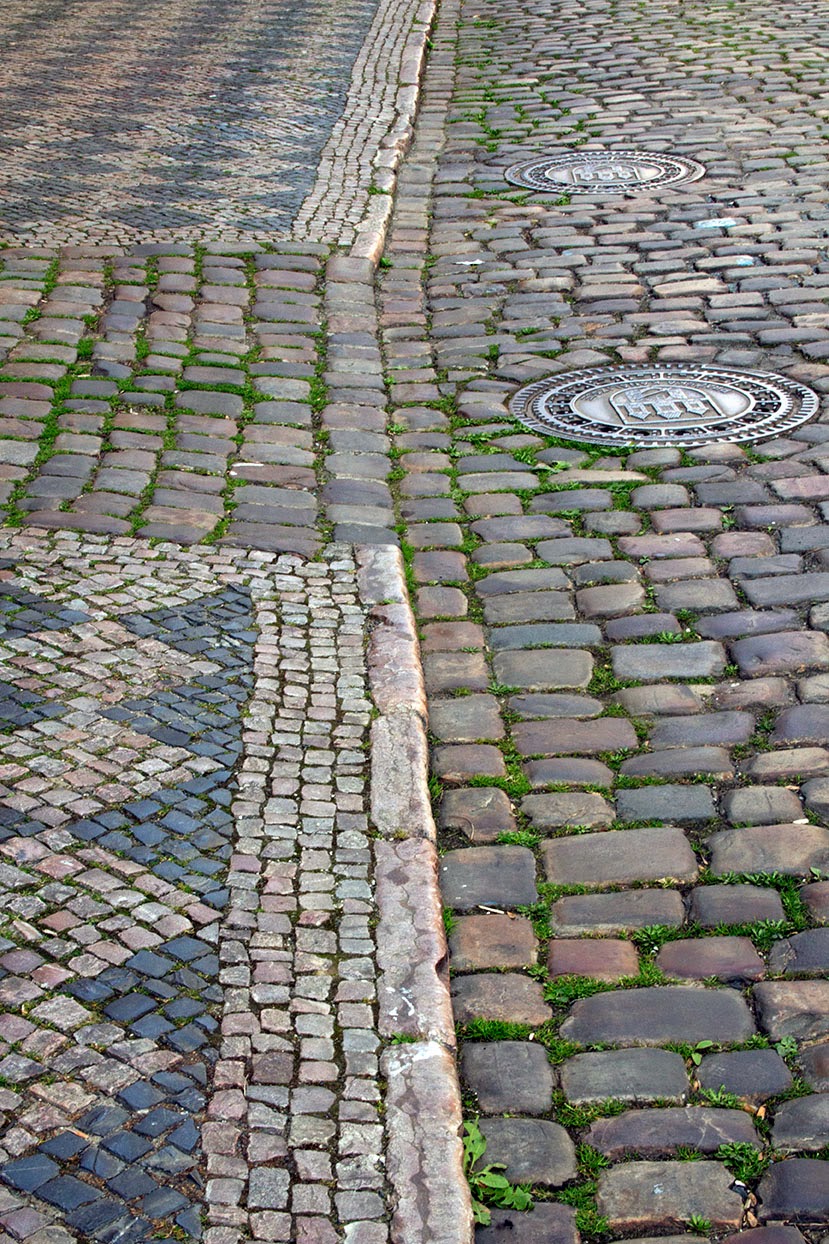 centuries old sidewalk of Prague with manholes