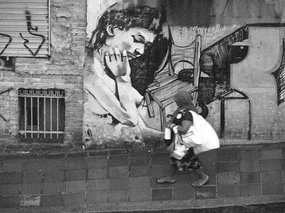 senhora andando na calçada em um dia chuvoso