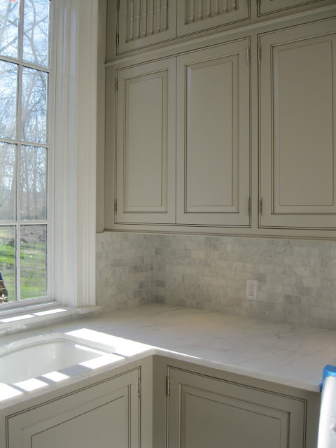 During construction Enchanted Home marble subway backsplash kitchen cabinets and sink