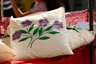 Capa de almofada com flores de quaremeira aplicadas de Ana Lúcia Fontes.