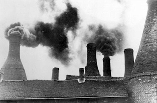 Bottle ovens being fired and creating smoke in The Potteries