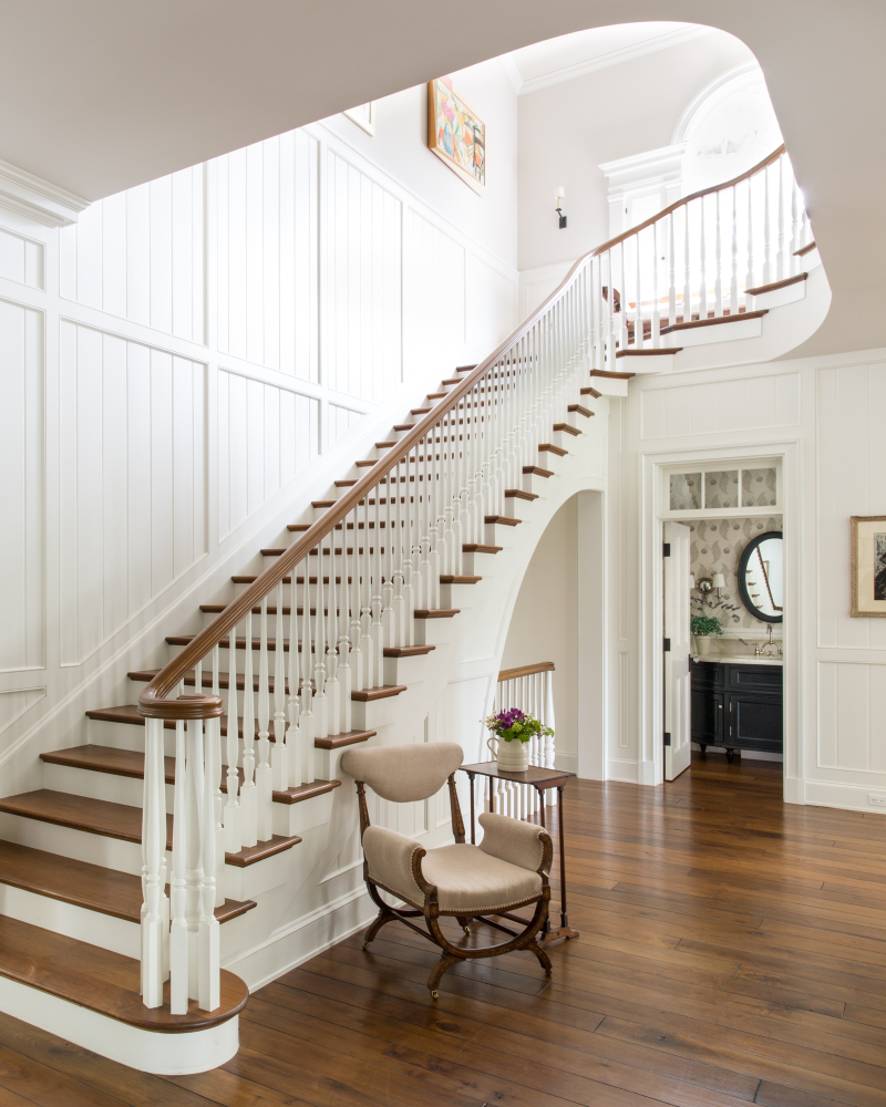 Giannetti Home Magnificent staircase, walnut floors, and paneled wall in traditional home by Giannetti Home