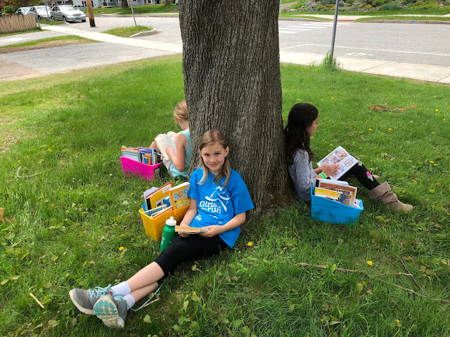 students reading against tree