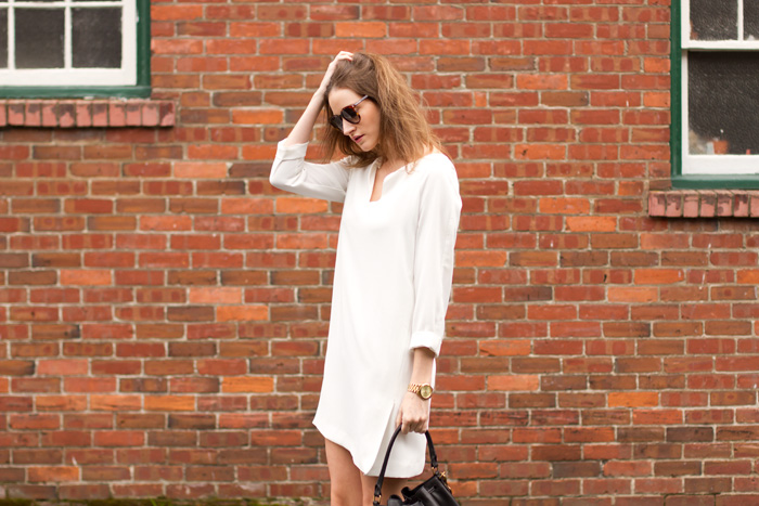 Vancouver fashion blogger, Alison Hutchinson, is wearing a white Zara dress, black Vince boots, a black leather Madewell bucket bag, and YSL sunglasses from Smart Buy Glasses