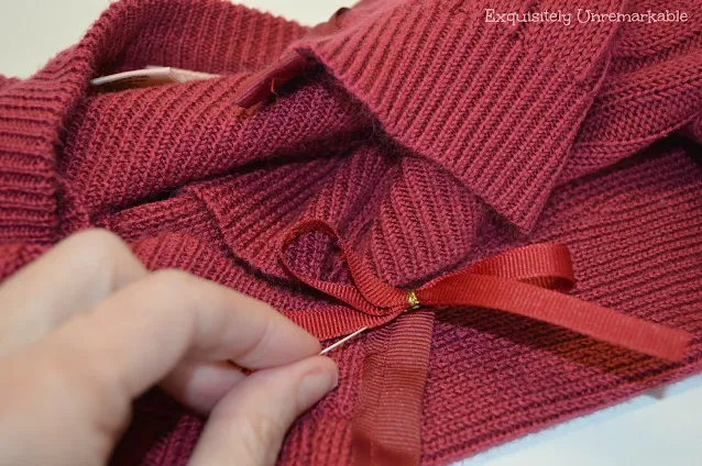 Stitching a bow onto a sweater neck