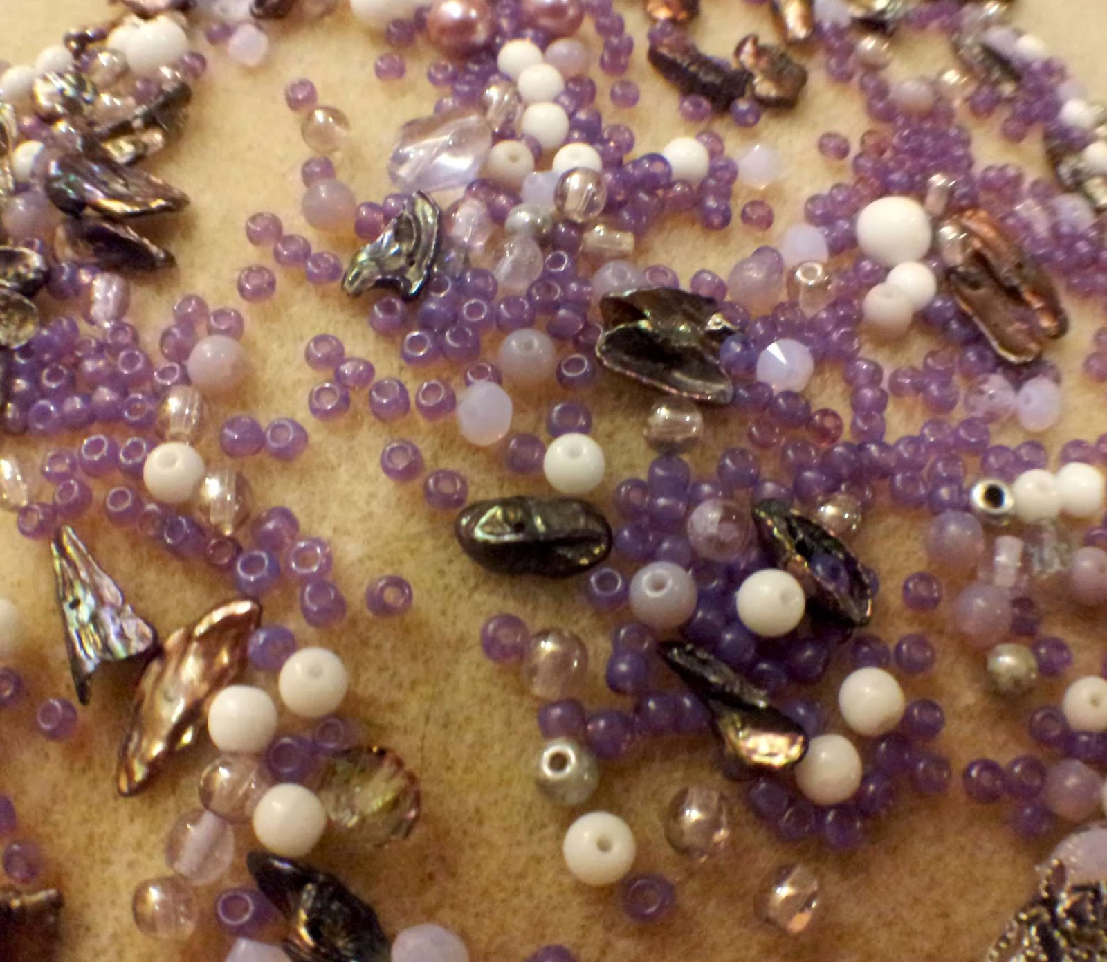 Into the forest elements: purple, white, and silver beads in various mediums (glass, ceramic, metal, glass pearls, mother of pearl) and teeny-tiny seed beads, along with a tree ceramic focal by Marla James :: All Pretty Things