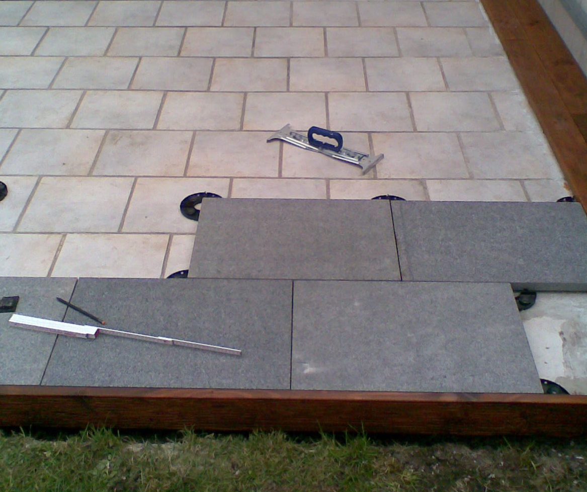 plain white: Eine Terrasse aus Granitplatten auf Stelzlagern