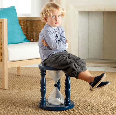 child sitting on hourglass timer stool