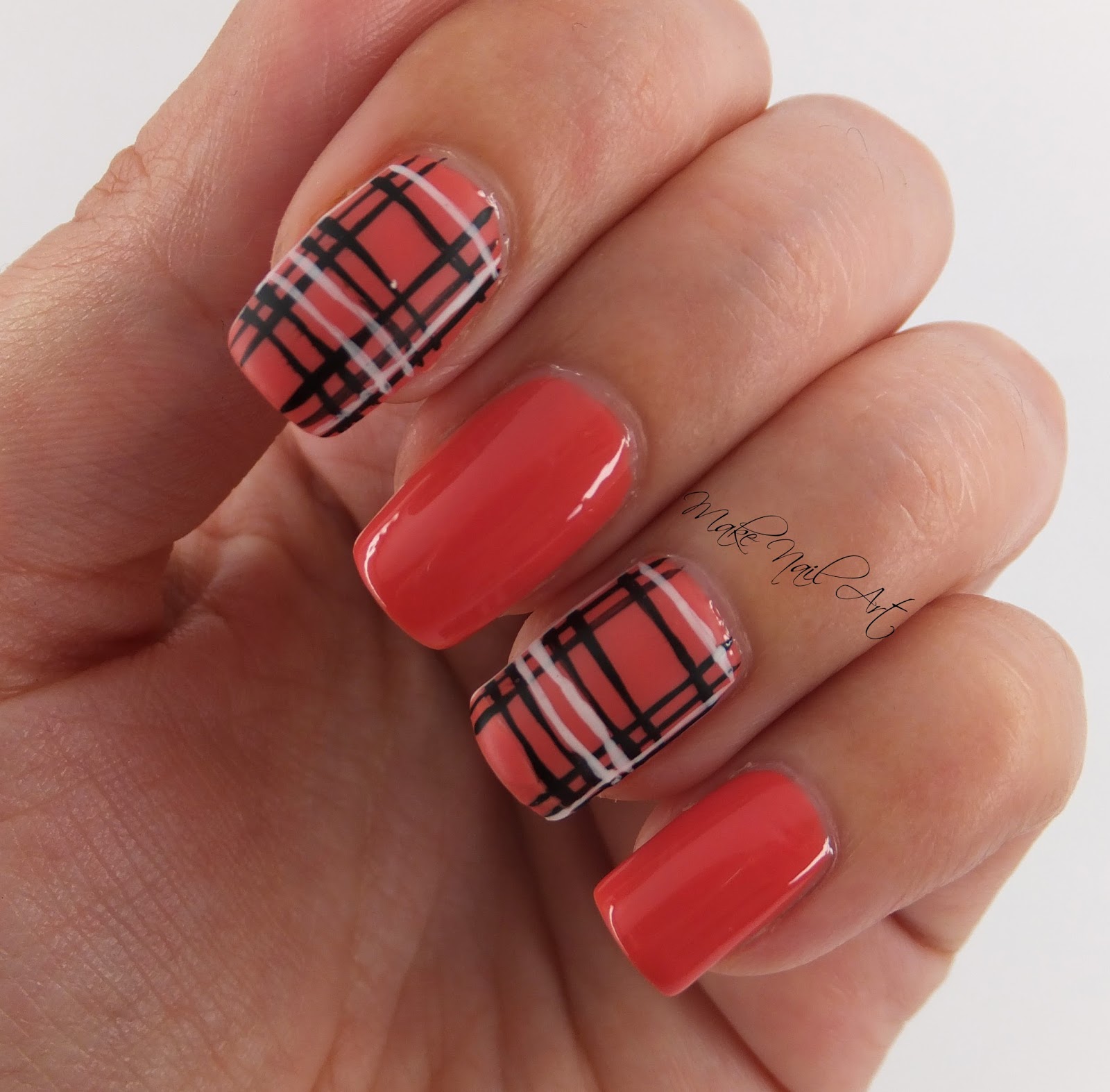 A hand with nails decorated with a plaid pattern in two contrasting colors