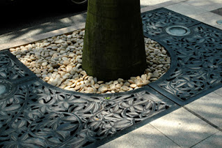 Floral pattern iron floor cover protecting trees along street