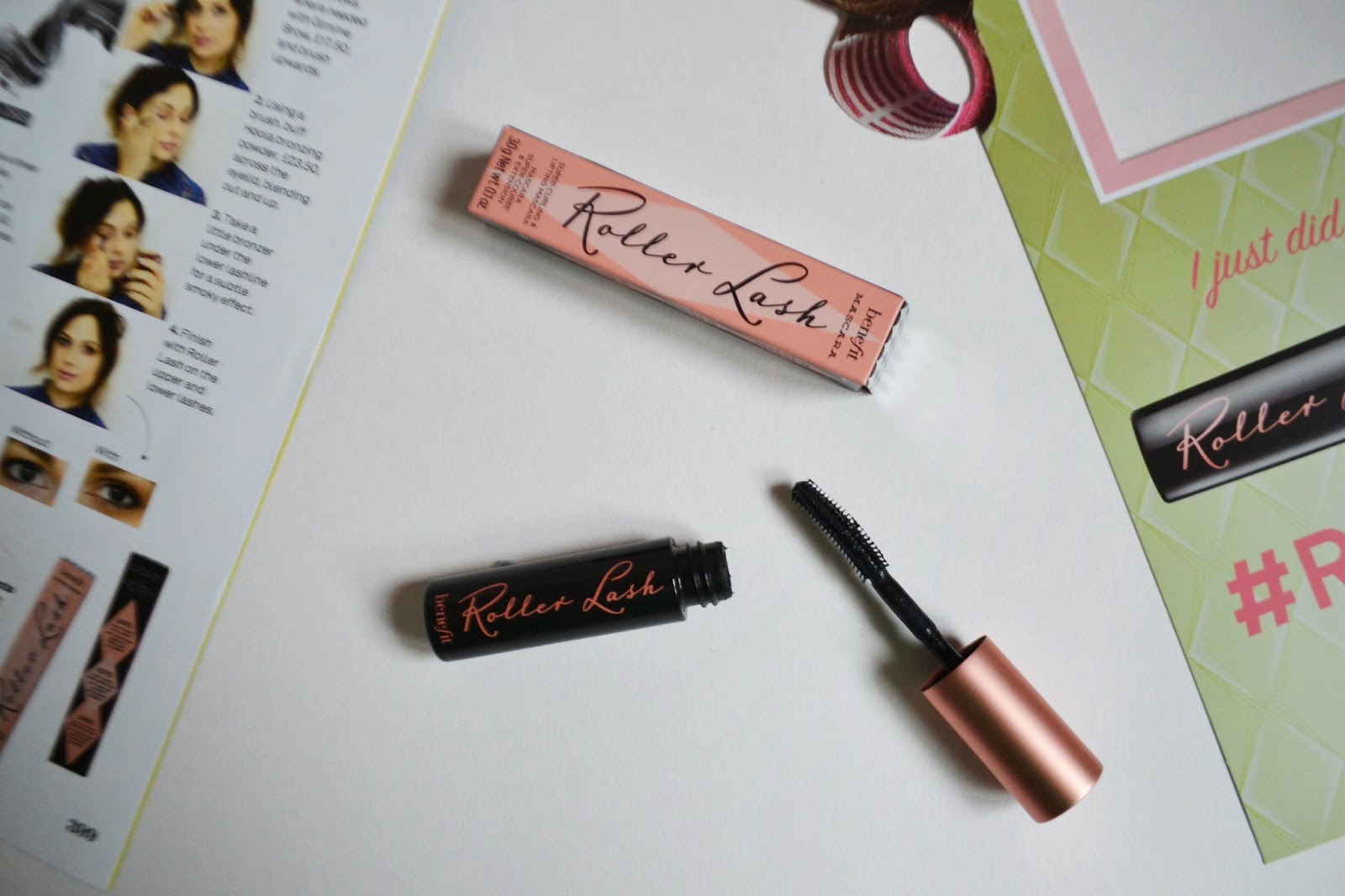 A flatlay image of the roller lash mascara open to show the wand, the mascara box can also be seen