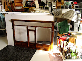 Modern dolls' house miniature half-built cafe on a work table.
