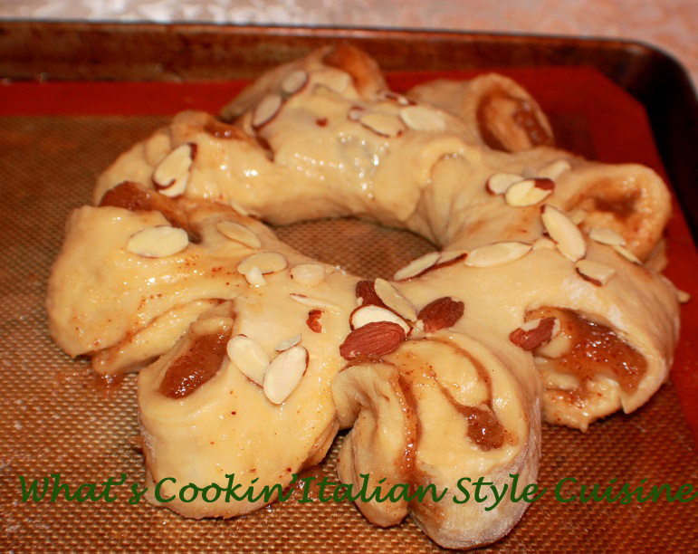 This is a sweet risen pastry dough filled with almond filling coffee cake with almonds on top and frosting.