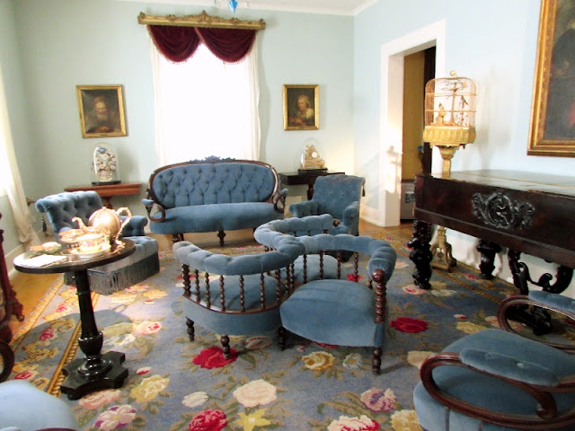 sala de convivio de esilo romântico com estofados azul e piano de cauda