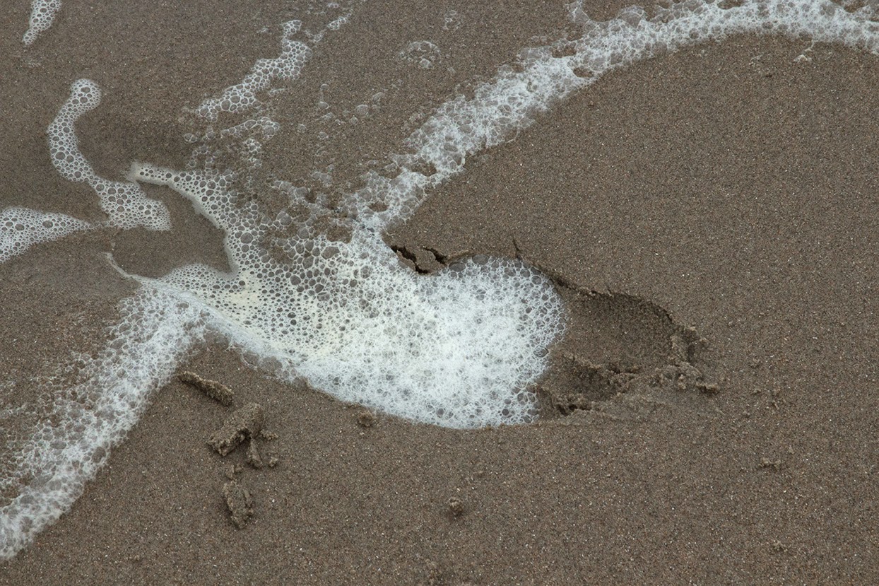 footstep filled with sea foam