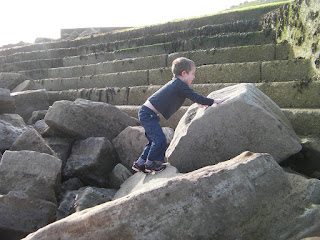 climbing large tidal defence rock formation on seashore southsea seafront