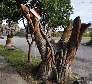 chainsaw carving of mermaid and dolphins