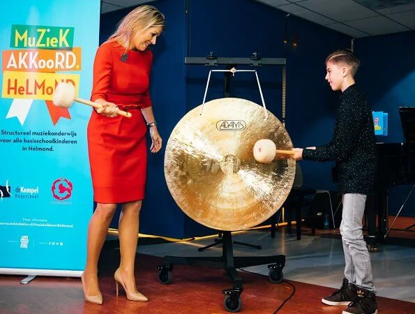 Queen Maxima wore a red dress by Vermeulen van Natan. The agreement is part of the program of The More Music in Classroom