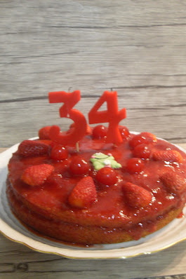 Pastel de cumpleaños de mermelada de fresas con fresas y cerezas sin lactosa.