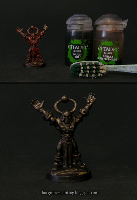 Photo showing a miniature with speckled, red overlay representing sprinling - with a tootbrush and a wash paints Agrax Earthshade and Nuln Oil visible on the right.