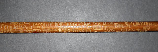 A photograph of a cane with significant carvings on it.