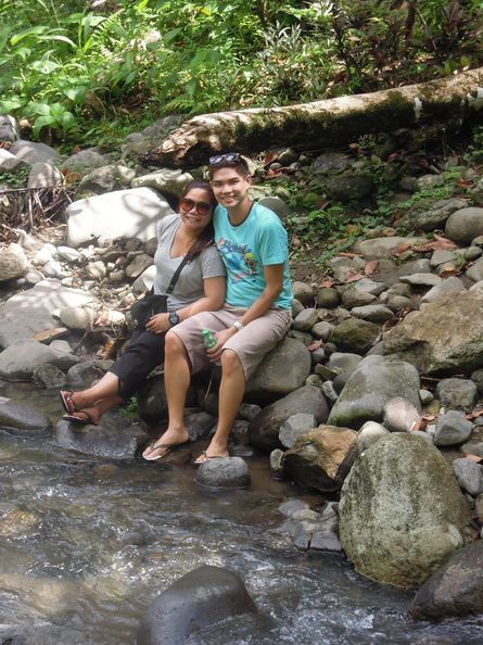A couple relaxing in Vera Falls' stream in Albay