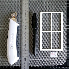 Cutting knife, metal ruler and black marker pen laid out on a plastic placemat with a translucent design (and a 49 cent sticker), with a one-twelfth scale plastic window frame on top.