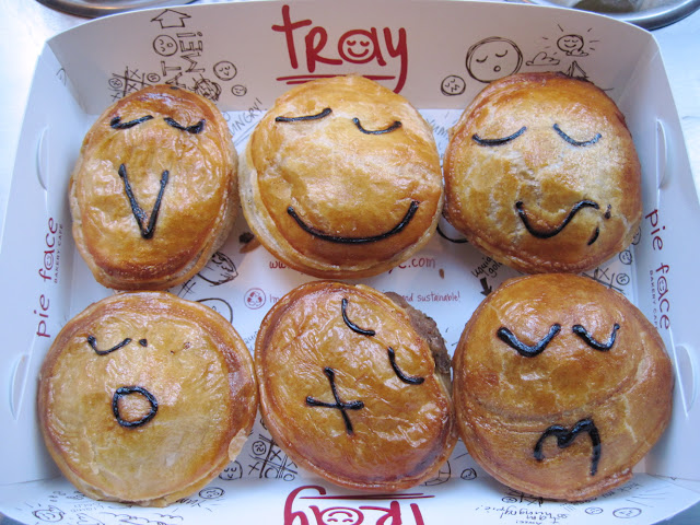A full tray of meat pies with unique faces artfully displayed by the artists of Pie Face a new in new york restaurant