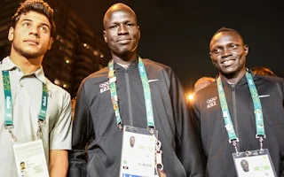 Three members of the Refugee Olympic Team attend a ceremony to welcome the team to the Olympic Village. © UNHCR/Benjamin Loyseau