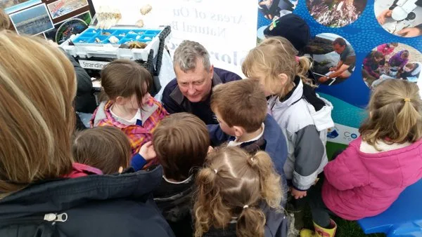 Combe Martin Bioblitz - Dave Edgecombe, surrounded by fascinated children explains the life of limpets