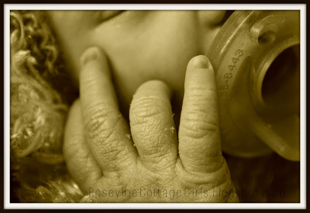 Sweetness of the fleeting moments by RosevineCottageGirls.com Photo is of a close up of an infant. It is wearing a baby bonnet and is suckling a pacifier. Its hand is on its cheek as it slumbers.