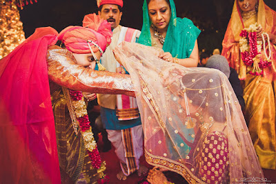 Groom Akshay lifting veil of bride