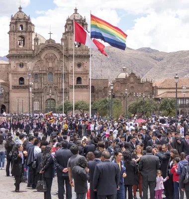 Cusco in 3 days: Plaza de Armas in Cusco Peru filled with a parade of students plus a rainbow flag