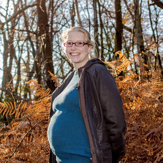 Standing in the autumnal forest with a 32 week bump