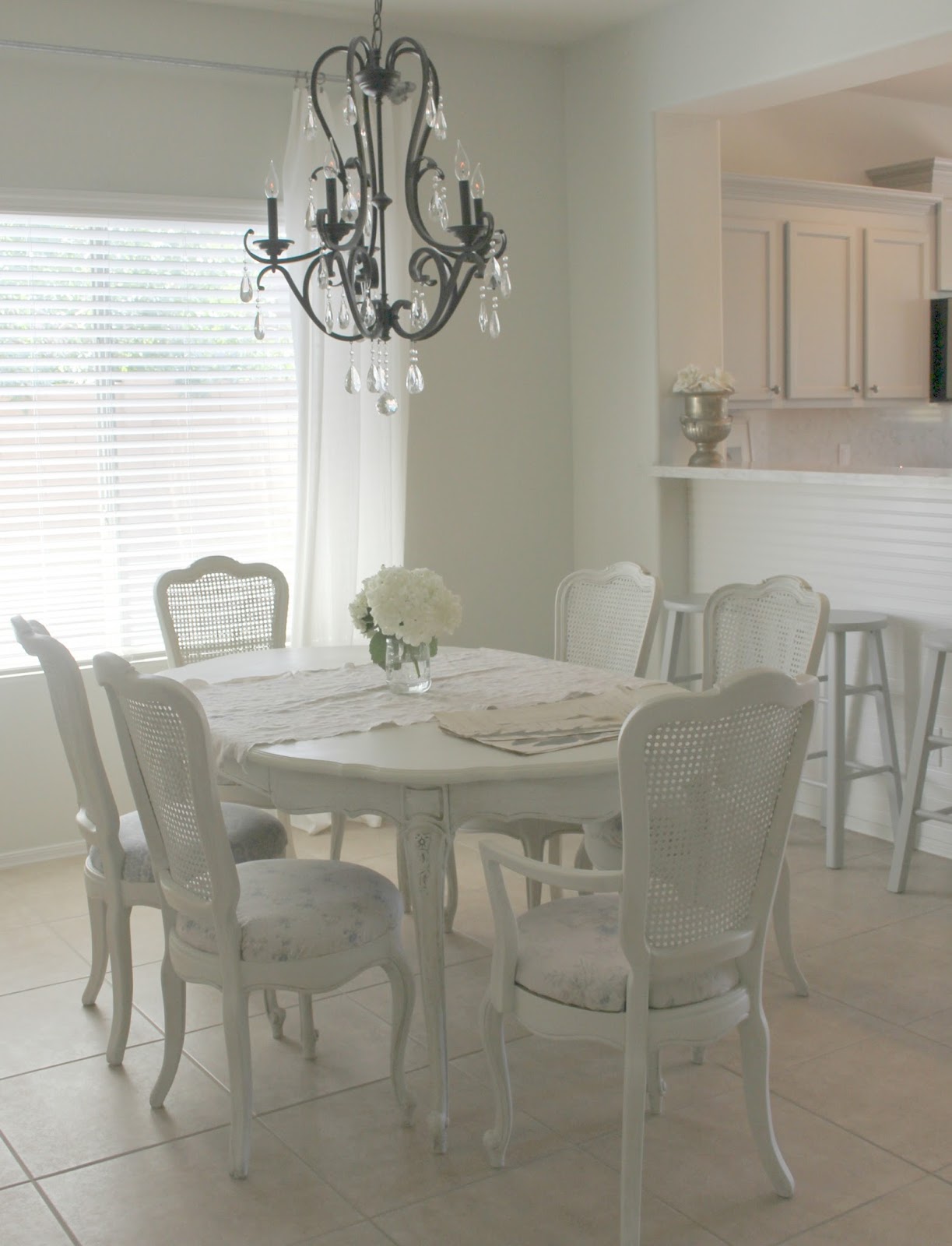 Shabby chic white dining room set with cane back chairs by Hello Lovely Studio