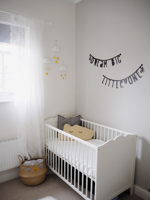 Gender neutral nursery room for a new baby boy or girl, in colour scheme grey and yellow featuring handmade accessories and interiors