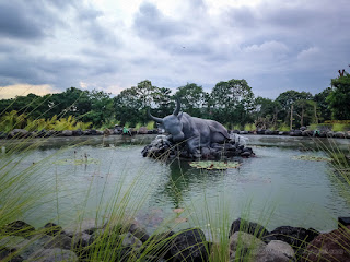 Sleeping Bull Statue In The Middle Of The Pond In The Garden Of The Park At Badung, Bali, Indonesia