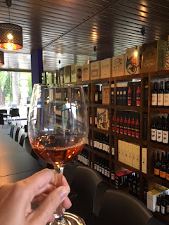 Conhecendo a Bacalhôa - vinícolas de Portugal loja da bacalhôa com taça de vinho moscatel na mão