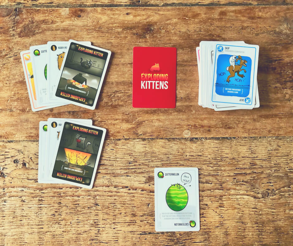 The finishing hands of Exploding Kittens set out on a table