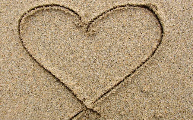 Foto met een hartje van zand op het strand